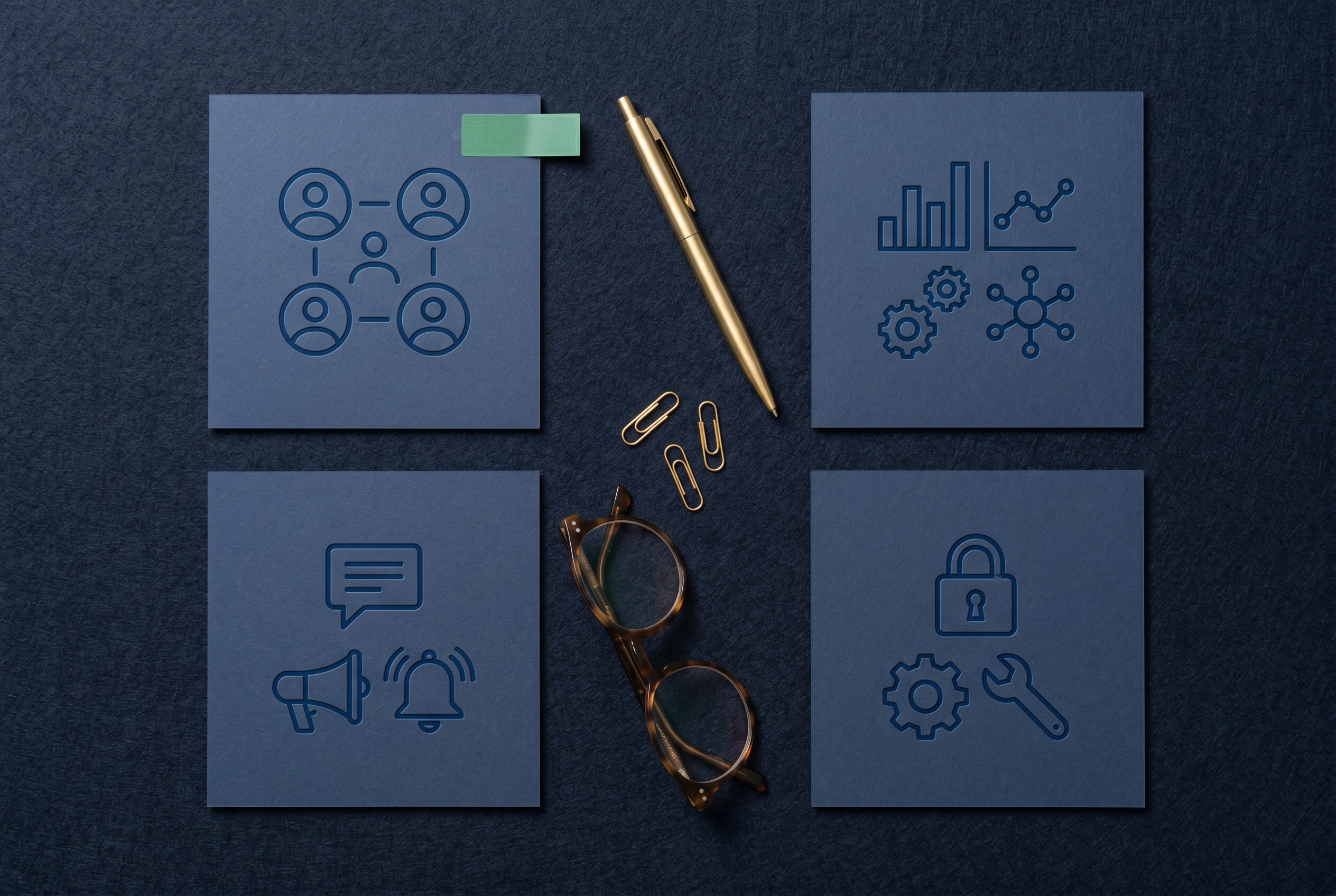 Top-down arrangement of feature cards with a gold pen and folded glasses